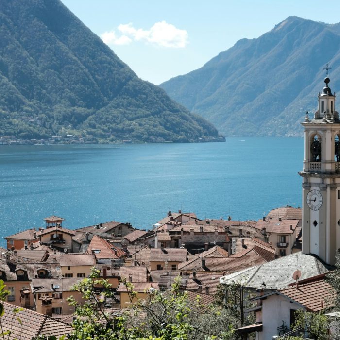 Stunning view of Lake Como from the village with a prominent bell tower against mountainous backdrop.